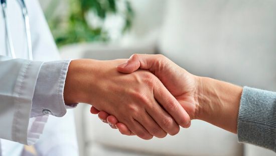Врач и пациент крепко жмут руки